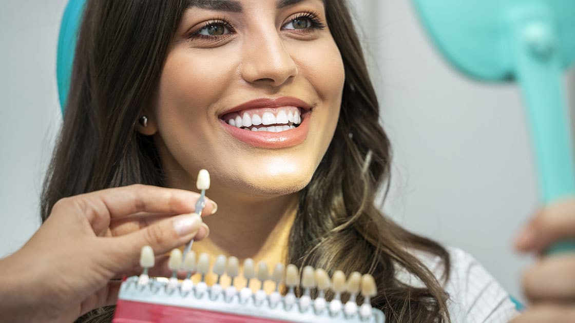 Tooth shade guide being held up to teeth